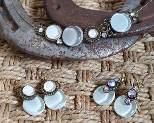 Collier et boucles d'oreilles avec des pierres blanches, sur un fer à cheval.