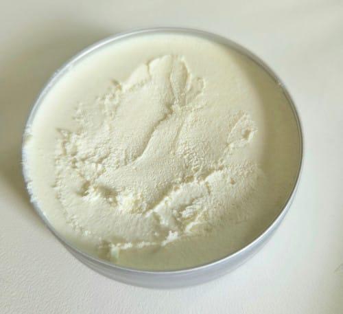 Gros pot de crème fouettée blanche dans un contenant rond.