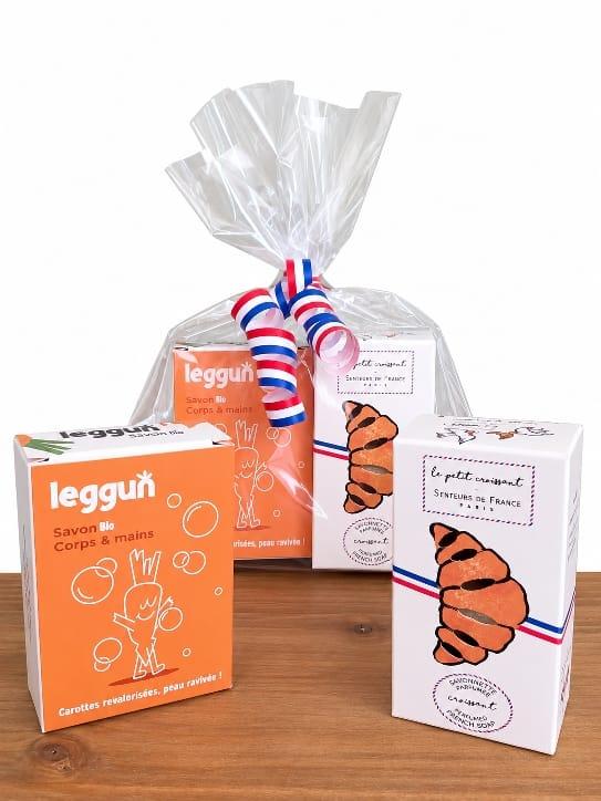 un sachet transparent contenant deux savons , un savon en forme de croissant et un savon à la carotte réformée , coffret d'ici et de claire 