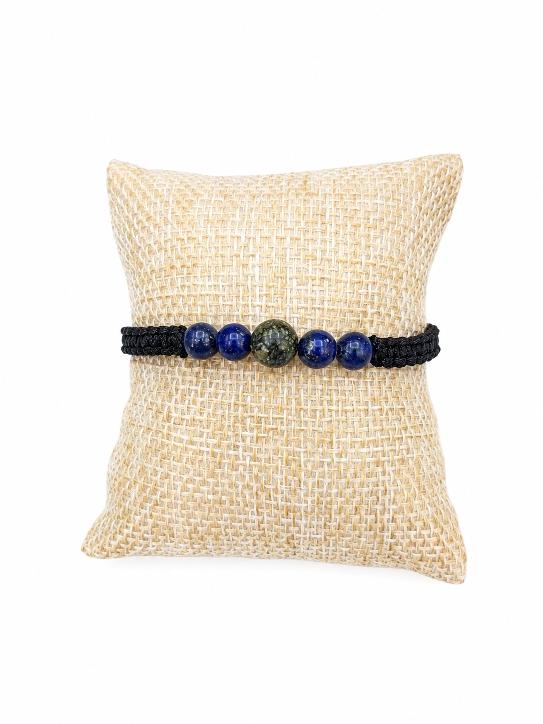 Bracelet tréssé avec des perles en pierres naturelles de plusieurs couleurs et un petit coussin beige sur fond blanc .D'Ici et de Claire 