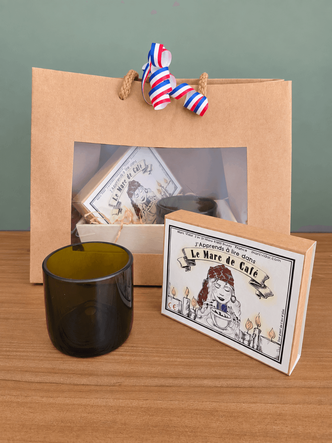 coffret avec une tasse en cul de bouteille et un jeu sur le marc de café de marc vidal dans un coffret carton , d'ici et de claire 