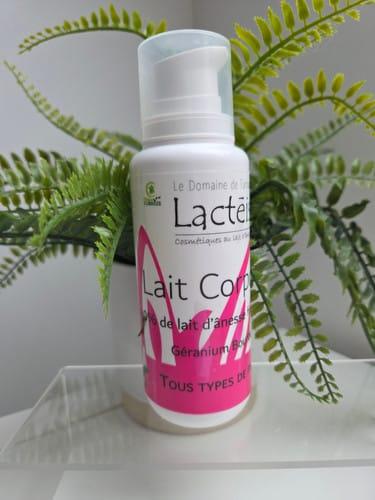 flacon de lait corporel au lait d'ânesse posé sur un support transparent